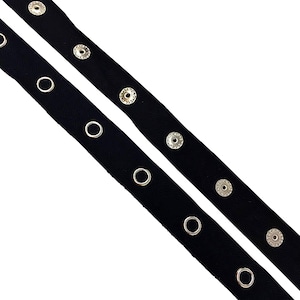 May include: Black ribbon trim with silver grommets. The ribbon is approximately 1 inch wide and has a satin finish.
