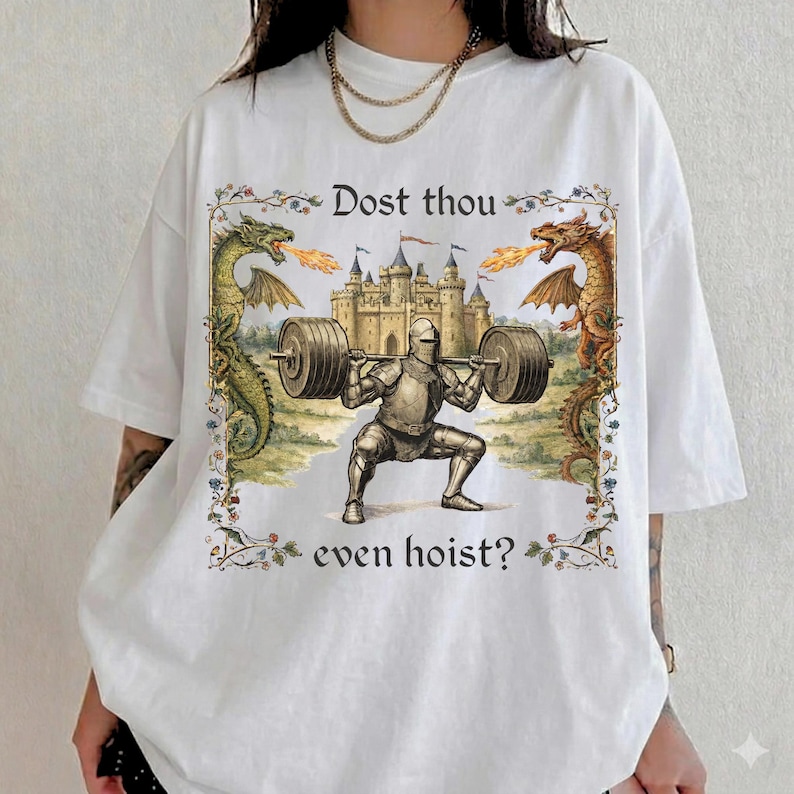 May include: White t-shirt featuring a medieval knight lifting weights, with a castle backdrop and dragons on either side. The text "Dost thou even hoist?" is printed above and below the knight illustration.