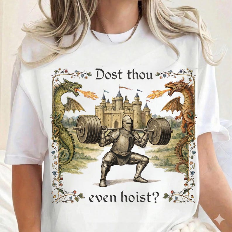 May include: White t-shirt with a medieval-themed graphic. The design features a knight lifting weights in front of a castle, flanked by dragons. Text reads "Dost thou even hoist?"