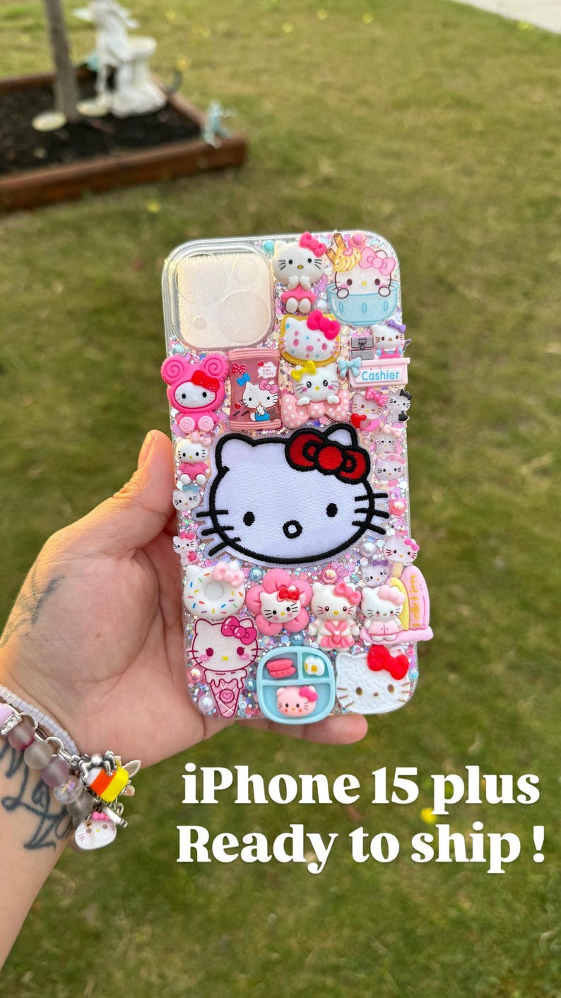Może przedstawiać: Przezroczyste etui na iPhone 15 Plus ozdobione postaciami Hello Kitty i innymi r&oacute;żowymi i białymi postaciami. Etui ma błyszczące tło i zawiera tekst "Cashier".