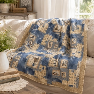 May include: A patchwork quilt featuring a repeating pattern of blue and beige squares. The design includes solid blue blocks, beige blocks with small floral motifs, and squares depicting small illustrations of baskets and garden-themed items.