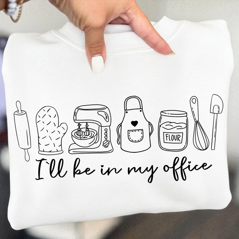 May include: White sweatshirt featuring a black line drawing of baking equipment: rolling pin, oven mitt, mixer, apron, flour jar, whisk, and spatula. The text "I'll be in my office" is below the drawing.