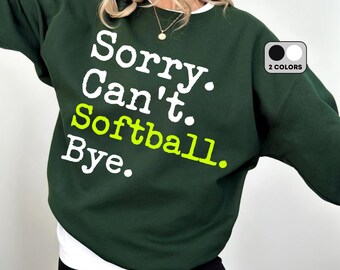 May include: A dark green sweatshirt with the text "Sorry. Can't. Softball. Bye." in white and neon green lettering.