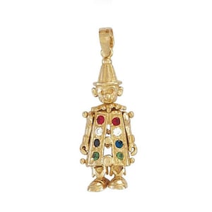 May include: A gold-coloured clown pendant. The pendant features a pointed hat, a round face, and a coat decorated with colourful gemstones. The design includes detailed features and a loop for attaching to a chain.