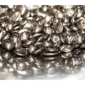 May include: Close-up of a pile of small, irregularly shaped, silver-colored metal pieces. The pieces have a reflective surface, and the lighting creates highlights and shadows, giving them a three-dimensional appearance. The overall effect is a textured, metallic display.