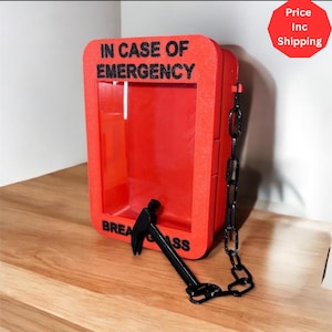May include: A red box with the text "IN CASE OF EMERGENCY" in black. A small black hammer is attached to the box with a chain. The words "BREAK GLASS" are printed on the bottom of the box.
