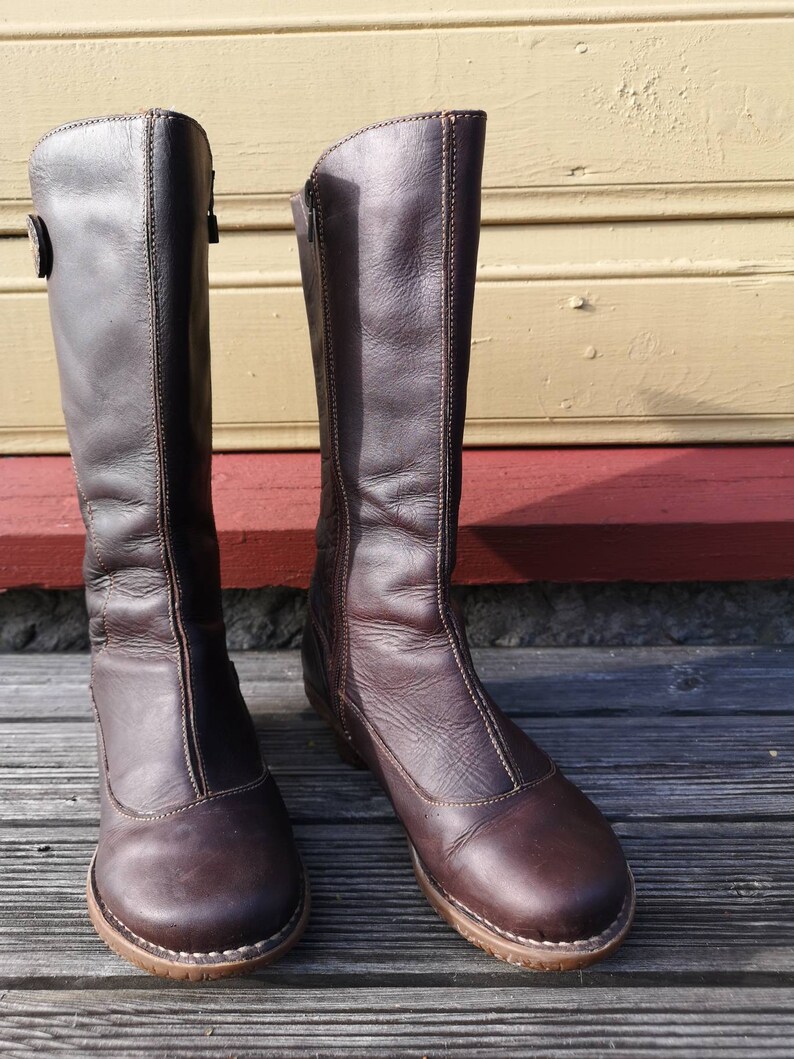 Front view of El Naturalista boots in dark brown leather with a clean, classic design, highlighting their rustic charm and durable craftsmanship.