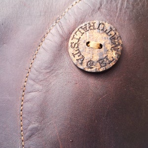 Close-up of the El Naturalista logo on a circular detail, emphasizing the brand’s eco-friendly ethos and handcrafted quality.