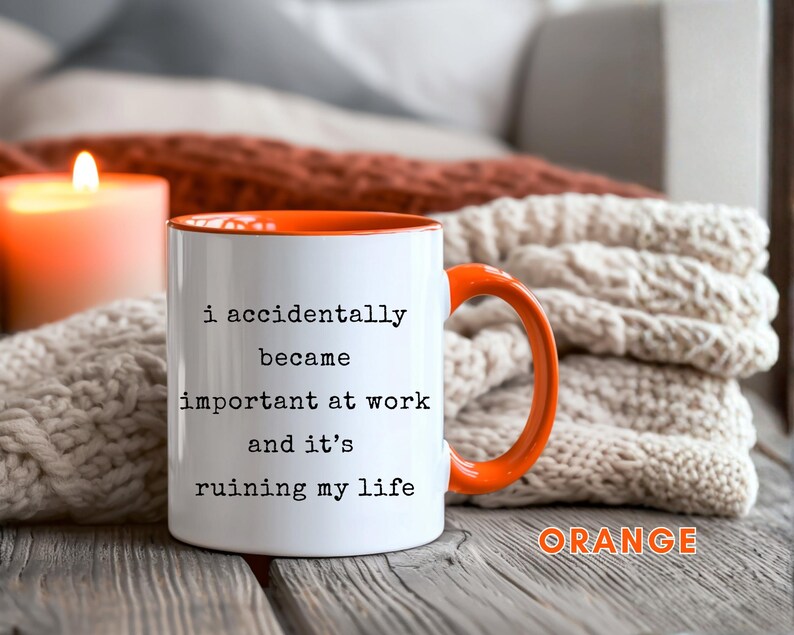May include: White ceramic mug with an orange interior and handle. The mug features the text "i accidentally became important at work and it's ruining my life" in black. The word "ORANGE" is written in orange at the bottom right.