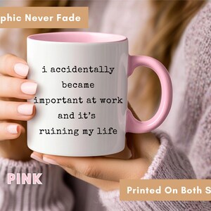 May include: White ceramic mug with a pink interior and handle. The mug has the text "i accidentally became important at work and it's ruining my life" printed on it. The words "Graphic Never Fade", "PINK", and "Printed On Both Sides" are also visible.