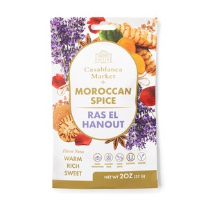 May include: A gold pouch with a white label that reads "Casablanca Market Moroccan Spice Ras El Hanout". The label also includes the text "Warm Rich Sweet" and "Net Wt 2OZ (57 g)". The pouch is decorated with images of spices, herbs, and flowers.