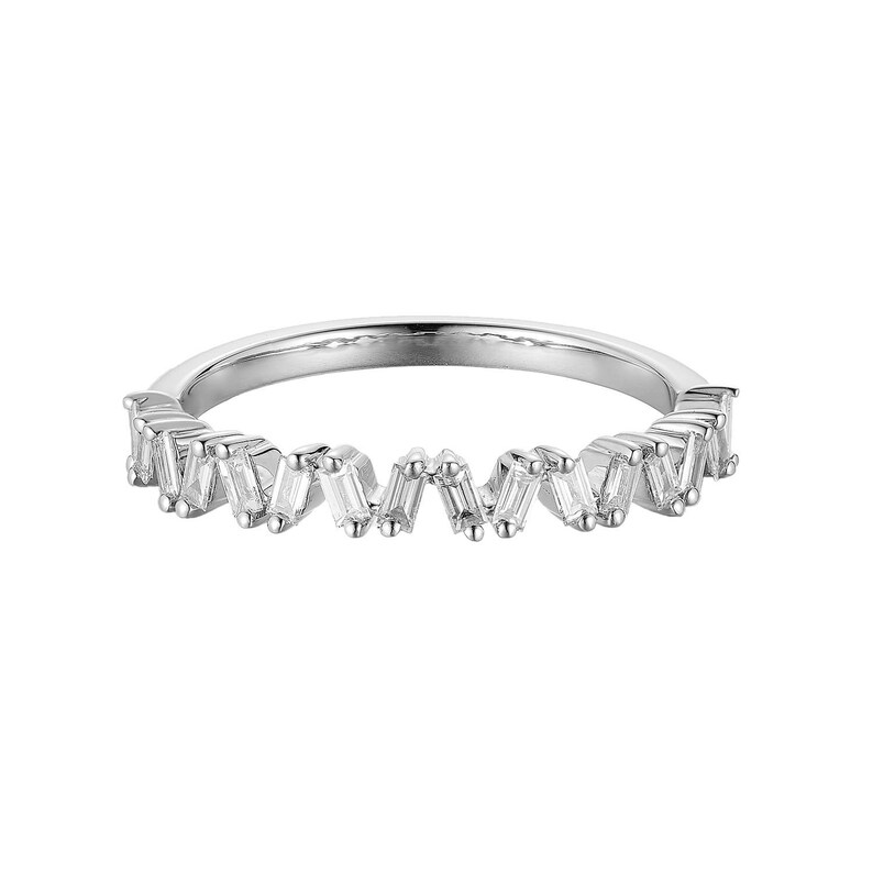 May include: A silver ring with a zig-zag pattern of rectangular, clear gemstones. The ring band is thin and polished, and the gemstones are set closely together, creating a continuous, sparkling design. The ring is set against a white background.