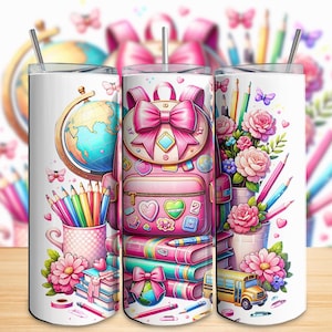 Op de afbeelding: Drie witte geïsoleerde bekers met schoolthema-ontwerpen. Eén heeft een roze rugzak, een andere een wereldbol en potloden, en de derde, bloemen en een schoolbus. Elke beker heeft een zilveren rietje en is versierd met kleurrijke illustraties.