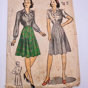 May include: Vintage sewing pattern for a skirt and blouse. The pattern is for size 14, bust 32. The pattern is printed on a light brown paper with a faded image of two women wearing the skirt and blouse. The skirt is a plaid pattern and the blouse has a collar and a pocket.