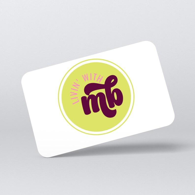 May include: A white gift card with rounded corners. The card features a circular logo with the words "Livin' With" in a light green circle, and the letters "mb" in a dark purple, stylized font.