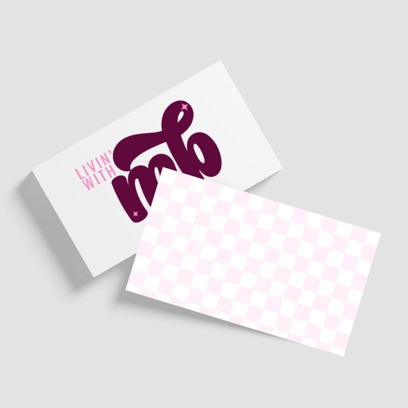 May include: Two white business cards. One card features the text "Livin' With" in pink and "mb" in a dark purple script with star accents. The second card has a pink and white checkered pattern.
