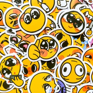May include: A collection of yellow smiley face stickers with various expressions, including surprised, blushing, and crying. The stickers are all hand-drawn and have a cartoon style.