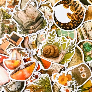 May include: A collection of colorful stickers featuring various illustrations, including a snail, mushrooms, a book, a clock, and a crescent moon with stars. The stickers are printed on white paper and have a glossy finish.