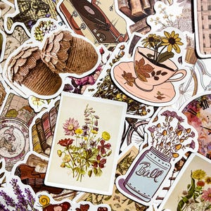 May include: A collection of vintage-style stickers featuring floral designs, a teacup with flowers, a record player, and a mason jar with flowers. The stickers are printed on white paper with a matte finish.