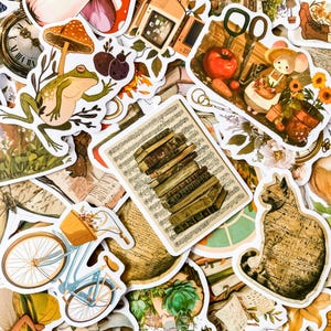 May include: A collection of vintage-style stickers featuring a variety of designs, including a frog, a cat, a stack of books, a bicycle, and a mushroom. The stickers are printed on white paper with a distressed, vintage look.