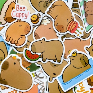 May include: A collection of cartoon stickers featuring capybaras in various poses. Some capybaras are eating watermelon, wearing party hats, or floating in water. One sticker has the text "Bee Cappy!" with a bee.
