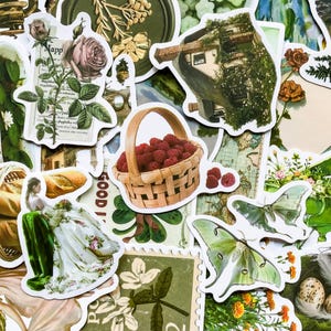 May include: A collection of vintage-style stickers featuring a variety of images, including a basket of red raspberries, a house in a tree, a woman in a white dress, a butterfly, and a floral design. The stickers are printed on white paper and have a distressed, vintage look.