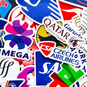 May include: A selection of colourful stickers displaying airline logos such as Qatar Airways and Czech Airlines. The stickers vary in shape and design, incorporating text and graphic elements, creating a vibrant and diverse collection.