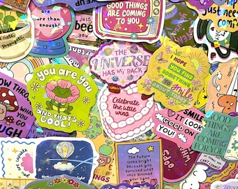 May include: A collection of colourful holographic stickers featuring various illustrations and motivational text including phrases like The Universe Has My Back, Celebrate the Little Wins, and You Are You And That's Cool, arranged in a dense overlapping pattern.
