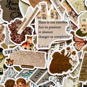 May include: A collection of vintage-style stickers with various designs, including flowers, a heart with vines, and text that reads "There is one emotion that its presence or absence changes us completely - Love."