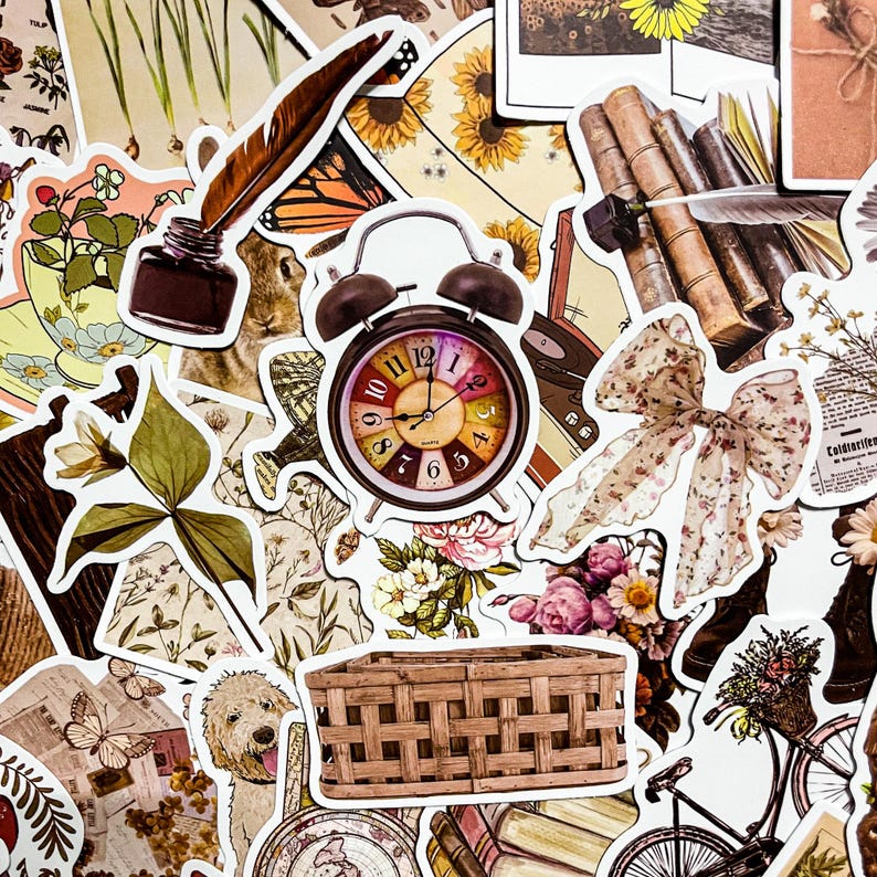 May include: A collection of vintage-style stickers featuring various designs, including a clock, a wicker basket, a floral bouquet, a butterfly, a quill pen, a book stack, a bow, and a bicycle. The stickers are printed on white paper with a glossy finish.