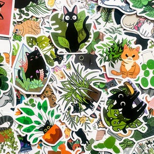 May include: A collection of stickers featuring black cats, plants, and other cute designs. The stickers are printed on white paper and have a glossy finish.