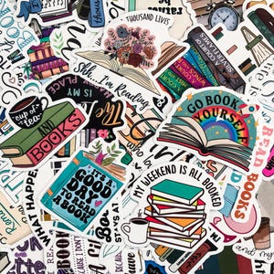 May include: A collection of colorful stickers with book-themed designs. The stickers feature open books, stacks of books, and phrases like "Go Book Yourself" and "It's a Good Day to Read a Book."