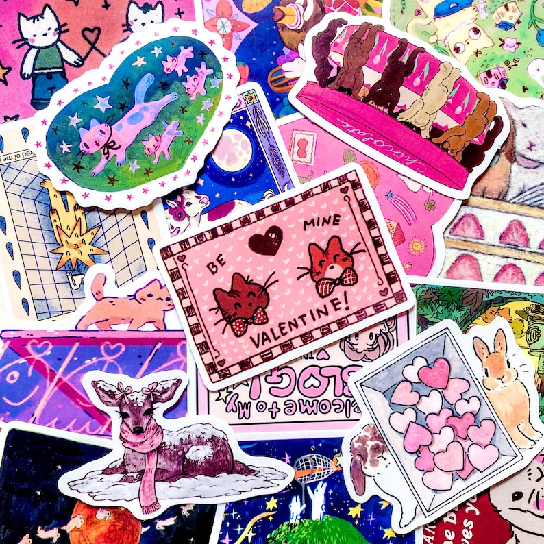 Pu&ograve; includere: Una collezione di adesivi colorati con vari disegni. Sono incluse illustrazioni di gatti, un cervo con una sciarpa e un adesivo di San Valentino con la scritta "Be Mine Valentine!". Altri adesivi raffigurano conigli e cuori.