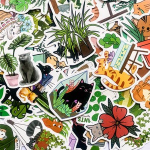 May include: A collection of colourful stickers featuring cats, plants, and geometric shapes. The stickers are printed on white paper and have a glossy finish.