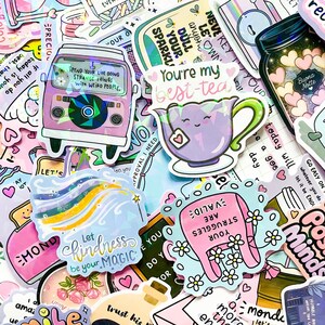 May include: A collection of colorful stickers with various designs and text. Stickers include a purple van, a teapot with the text "You're my best-tea", and a sticker with the text "Let kindness be your magic".