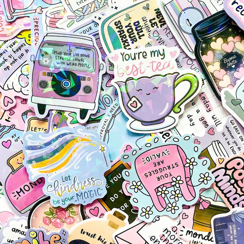May include: A collection of colorful stickers with various designs and text. Stickers include a purple van, a teapot with the text "You're my best-tea", and a sticker with the text "Let kindness be your magic".