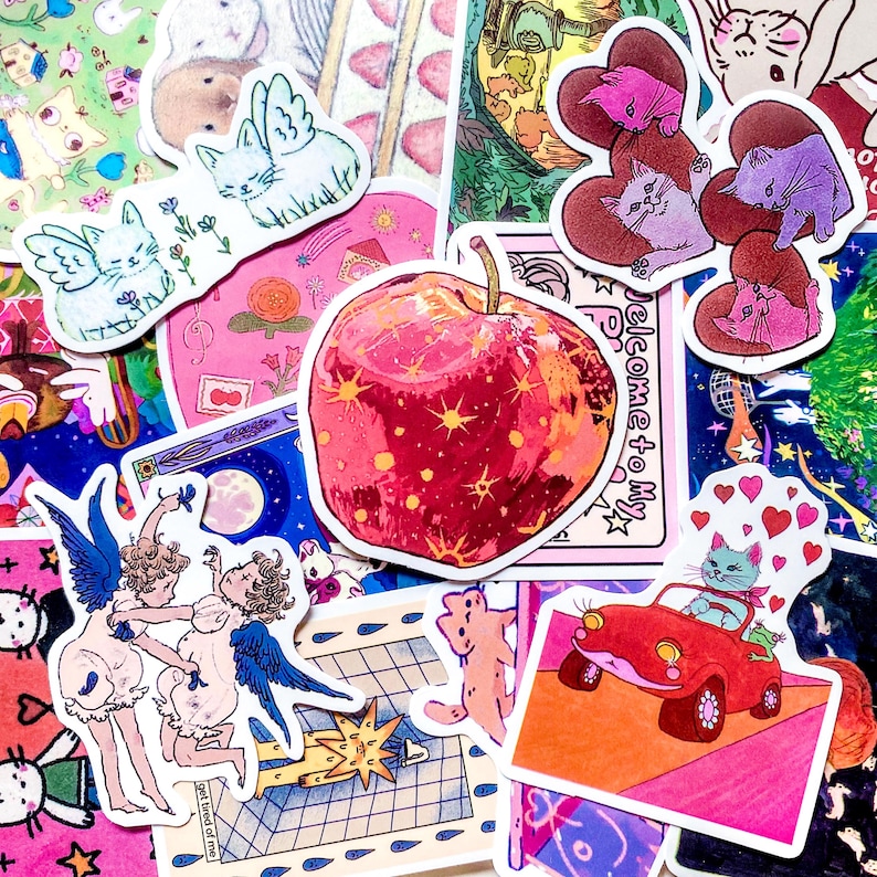 Pu&ograve; includere: Una collezione di adesivi colorati con vari disegni. Include una grande mela rossa con stelle gialle, gatti alati, cherubini, gatti a forma di cuore e un gatto che guida un'auto rossa. Gli adesivi hanno uno stile illustrativo stravagante.