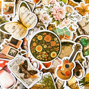 May include: A collection of vintage-style stickers featuring floral designs, butterflies, a guitar, a clock, and a retro television. The stickers are printed on white paper with a matte finish.