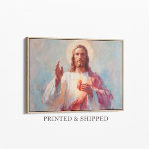 Peut inclure: Une impression d'art mural rectangulaire représentant une peinture d'une figure aux longs cheveux bruns et à la barbe, vêtue de robes blanches avec une écharpe rouge. La figure a un cœur brillant sur la poitrine et une auréole, une main levée.