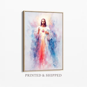 Puede incluir: Una impresión artística enmarcada que presenta una representación al estilo acuarela de Jesucristo con un Sagrado Corazón brillante. La figura está centrada sobre un fondo etéreo y suave de tonos azules, rosas y blancos mezclados, con rayos de luz.