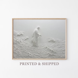 Puede incluir: Impresión en relieve blanca enmarcada que representa una figura con túnica caminando sobre el agua, con patrones de olas detallados. La obra de arte está sobre un fondo claro, con un marco de madera natural.