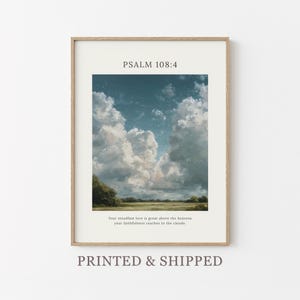 Op de afbeelding: Ingelijste kunstdruk met een landschapsschilderij van een bewolkte lucht boven een veld. De tekst "PSALM 108:4" staat bovenaan, met daaronder een bijbelvers. De print zit in een licht houten frame.