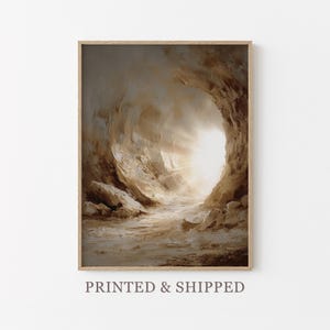 May include: A framed art print showing a cave entrance with a bright light source in the middle. The painting uses a textured style with brown, beige, and white tones. The text "PRINTED & SHIPPED" is printed at the bottom of the frame.