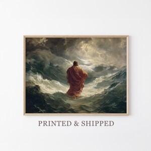 May include: Framed print of a painting showing a figure in a red robe walking on water in a stormy sea. The artwork has dramatic lighting and a dark, cloudy sky. The print is in a wooden frame.