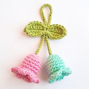 Lily of the Valley crochet keychain pattern with pink and mint bell-shaped flowers and green leaf loop.