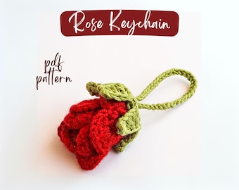 Peut inclure: Un porte-clés en forme de rose crochetée rouge avec des feuilles vertes et une boucle verte. Le texte "Rose Keychain" est dans une bannière bordeaux au-dessus de la rose. Le texte "pdf pattern" est en script noir.