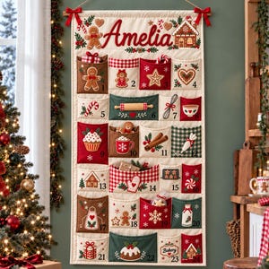 May include: A fabric wall-hanging advent calendar with the name Amelia embroidered at the top. It features twenty-four numbered pockets decorated with festive gingerbread, candy cane, and holiday baking motifs in red, green, and brown.