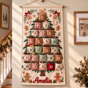 Può includere: Un calendario dell'avvento in tessuto da appendere con un disegno di albero di Natale stampato e ventiquattro tasche numerate. Il tessuto color crema mostra casette di pan di zenzero, bastoncini di zucchero e il nome Amelia in rosso.
