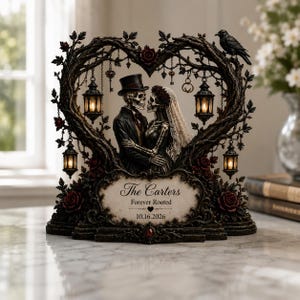 May include: A decorative sculpture featuring two skeletons in wedding attire standing under a heart-shaped tree branch arch. The piece includes four hanging lanterns, a black raven, and a plaque with the text The Carters, Forever Rooted, 10.16.2026.