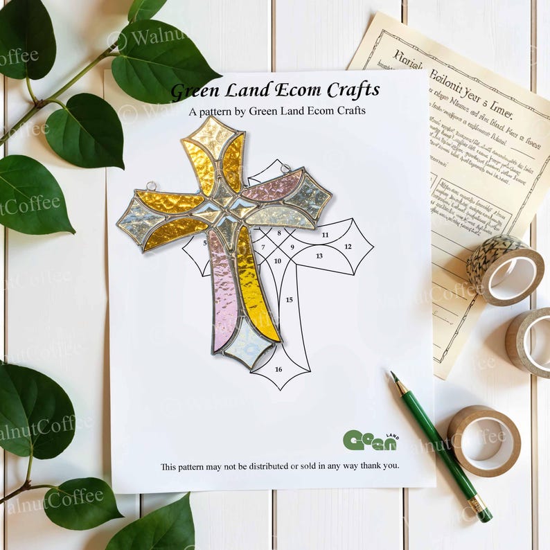 K&ouml;nnte beinhalten: Ein Buntglaskreuz mit goldenen, rosa und silbernen Abschnitten, das auf einem Musterbogen liegt. Auf dem Bogen steht der Text "Green Land Ecom Crafts". Ein gr&uuml;ner Bleistift und Klebebandrollen sind ebenfalls zu sehen.